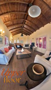 a large living room with couches and a wooden ceiling at Stone Villa Maria in Galaxidhion