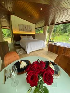 una camera con letto e un tavolo con rose di Loft Vidro View Rota do Vinho São Roque a São Roque