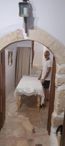 a man standing next to a table in a room at Villa ABBA in Plaka