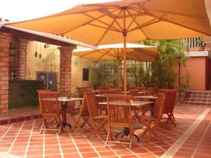 a restaurant with tables and chairs with umbrellas at Posada El Remanso de Pueblo Nuevo in San Cristóbal