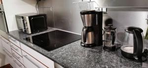 a kitchen counter with a coffee maker and a microwave at 3-bedroom lake view and near center apartment with sauna in Lahti +25 photos