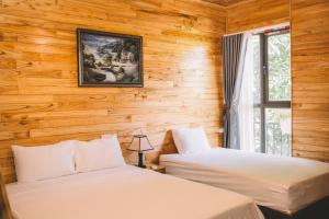 due letti in una stanza con pareti in legno di My Tam Coc Bungalow a Ninh Binh Altre 115 foto