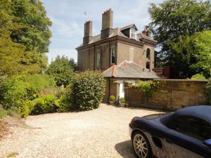an old house with a car parked in front of it at Beggar's Knap in Dorchester