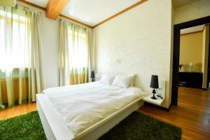 una camera da letto con un grande letto bianco con un tappeto verde di Luxury Apartment a Braşov