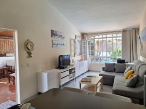 a living room with a couch and a tv at Oasis Los Porches in Playa del Ingles