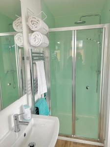 a bathroom with a glass shower and a sink at Hightide in Bude +3 photos