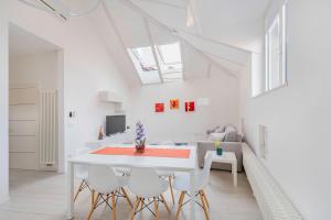 Un comedor blanco con una mesa y sillas blancas. en Sweethome Gries - Con Garage, en Bolzano