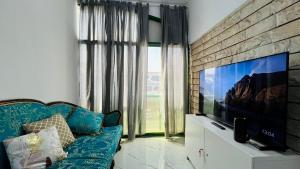 a living room with a blue couch and a flat screen tv at AD Villa Studio in Abu Dhabi +5 photos