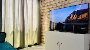 a flat screen tv sitting on top of a white cabinet at AD Villa Studio in Abu Dhabi