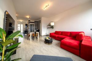a living room with a red couch and a table at Honey House - vista lago e montagne in Luino