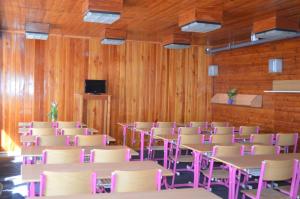 a room with tables and chairs and a television at Chata Alenka in Štítary