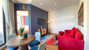 a living room with a red couch and a table at APEC Mandala - căn hộ in Ấp Thiẹn Ái
