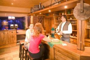 a group of women sitting at a bar in a kitchen at Amselgrundschlösschen in Kurort Rathen