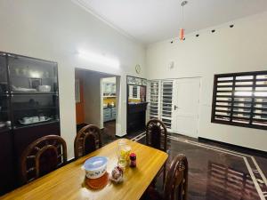 a dining room with a wooden table and chairs at Shibus in Thodupuzha