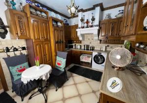 a kitchen with wooden cabinets and a table and chairs at Popis Maison in Rhodes Town