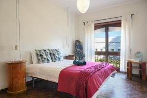 a bedroom with a bed with a red blanket on it at VIC Aveiro Arts House in Aveiro