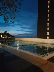 a swimming pool at night next to a building at AR Guesthouse D'Alanis in Sepang