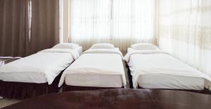 a row of beds in a room with a window at SN Garden in Ban Bo Hin