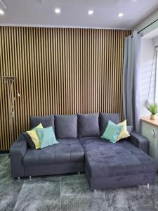 a blue couch with pillows in a living room at Studio Sudety osobne wejscie in Wałbrzych