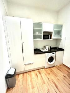a kitchen with white cabinets and a washing machine at Vienna Prater Apartment in Vienna