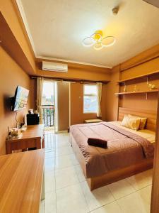 a large bedroom with a large bed and a desk at Kamar Apartemen Harian by Younz Apartmen Depok in Pondokcina