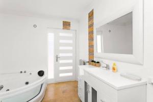 a white bathroom with a sink and a mirror at Relaxing Getaway Beachfront Access Multi Family Pets Mandurah in Mandurah +31 photos