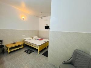兰奇Bimala Hotel的一间有一张床和一把椅子的小房间