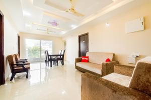 a living room with a couch and chairs and a table at Super Capital O RR Towers by CJ in Vijayawāda