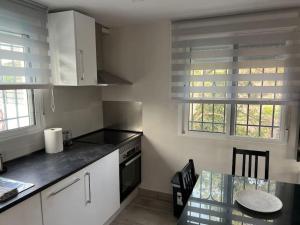 eine Küche mit einem Herd und einem Tisch darin in der Unterkunft Villa Dehesa 466 piscina-barbacoa-2hab in Torrox