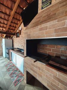 a kitchen with a brick wall with a fireplace at Estância Oliveira in Socorro