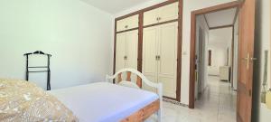 a bedroom with a bed and a door to a bathroom at Chalé Almaria in Oliva
