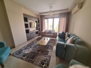 una sala de estar con un sofá y una mesa en Shared City Stay at Midtown Compound next to the AUC University, en El Cairo
