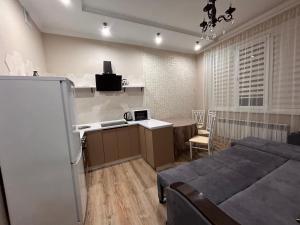 a bedroom with a bed and a kitchen and a table at Апартаменты с видом на море в центре in Aktau