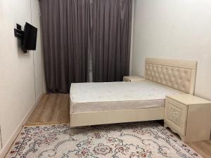 a small bedroom with a bed in a room at Апартаменты с видом на море в центре in Aktau
