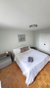 a bedroom with a large white bed with two shoes on it at Downtown Gem by the Subway in Toronto