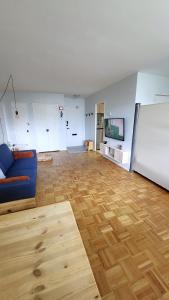 a living room with a blue couch and a wooden floor at Downtown Gem by the Subway in Toronto