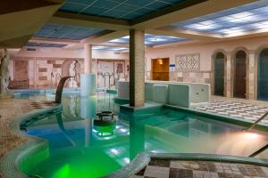 a pool in a hotel room with a hot tub at Hotel Comendador in Carranque
