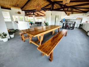 a wooden bench in a room with tables and chairs at Sentro Suites Siargao in General Luna
