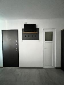 a white room with a door and a shelf on the wall at Maysa Ap in Turda +7 photos