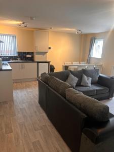 a living room with a couch and a kitchen at Brand new apartments with Open plan kitchens & Diner , FREE WIFI & NETFLIX included in Burton upon Trent +24 photos