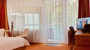 una camera da letto con un letto e una grande finestra di G&P Housing Apartments mit Küche & Balkon & HighSpeed Internet- Comfort ad Altensteig