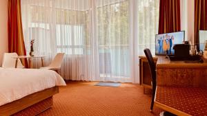 una camera da letto con un letto, una scrivania e una finestra di G&P Housing Apartments mit Küche & Balkon & HighSpeed Internet- Comfort ad Altensteig