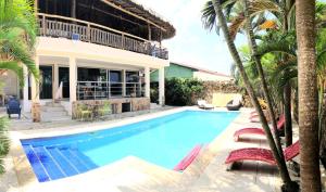 圣维罗尼卡Casa Basileia的棕榈树环绕的房子前的游泳池