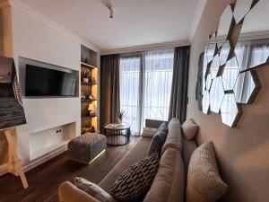 a living room with a couch and a tv at Central Park Mielno Operator Team- apartament IVO in Mielno