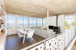 a kitchen and living room with a table and chairs at Stunning views to sea from Modern Villa El Mirador near Sitges in Canyelles