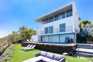 a large white building with a pool in front of it at Stunning views to sea from Modern Villa El Mirador near Sitges in Canyelles