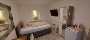 a small room with a bed and a mirror at Perfekt suite Sunny room 2 in Dinkelsbühl +41 photos