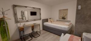 a small room with a bed and a mirror at Perfekt suite Sunny room 2 in Dinkelsbühl