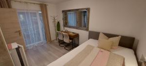 a small room with a bed and a desk and a mirror at Perfekt suite Sunny room 2 in Dinkelsbühl