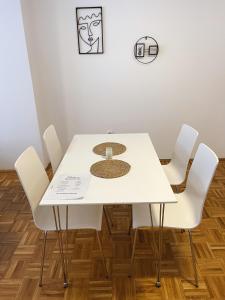 a white dining room table with white chairs at Apartment Troi in Pristina +10 photos